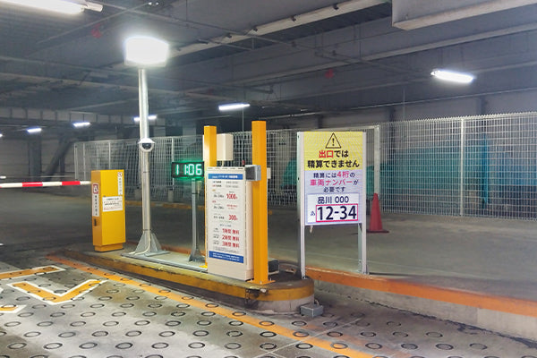 商業施設駐車場入口で精算方法案内を表示するデジタルサイネージ